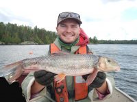 man in a boat holding a fish
