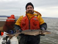 man in a boat holding a fish