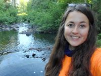 Woman posing in front of a stream